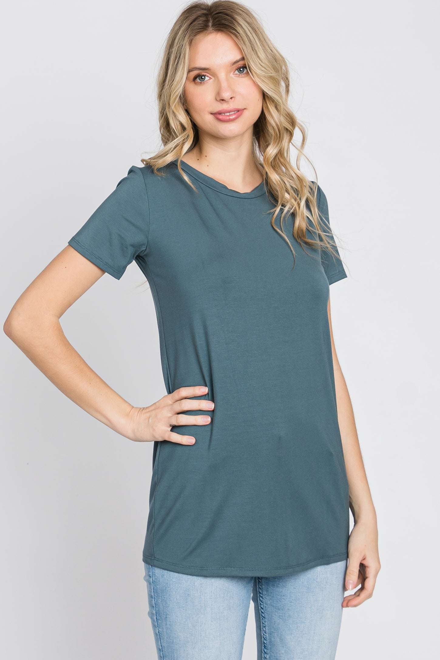 woman wearing a teal short sleeve t-shirt paired with light blue jeans