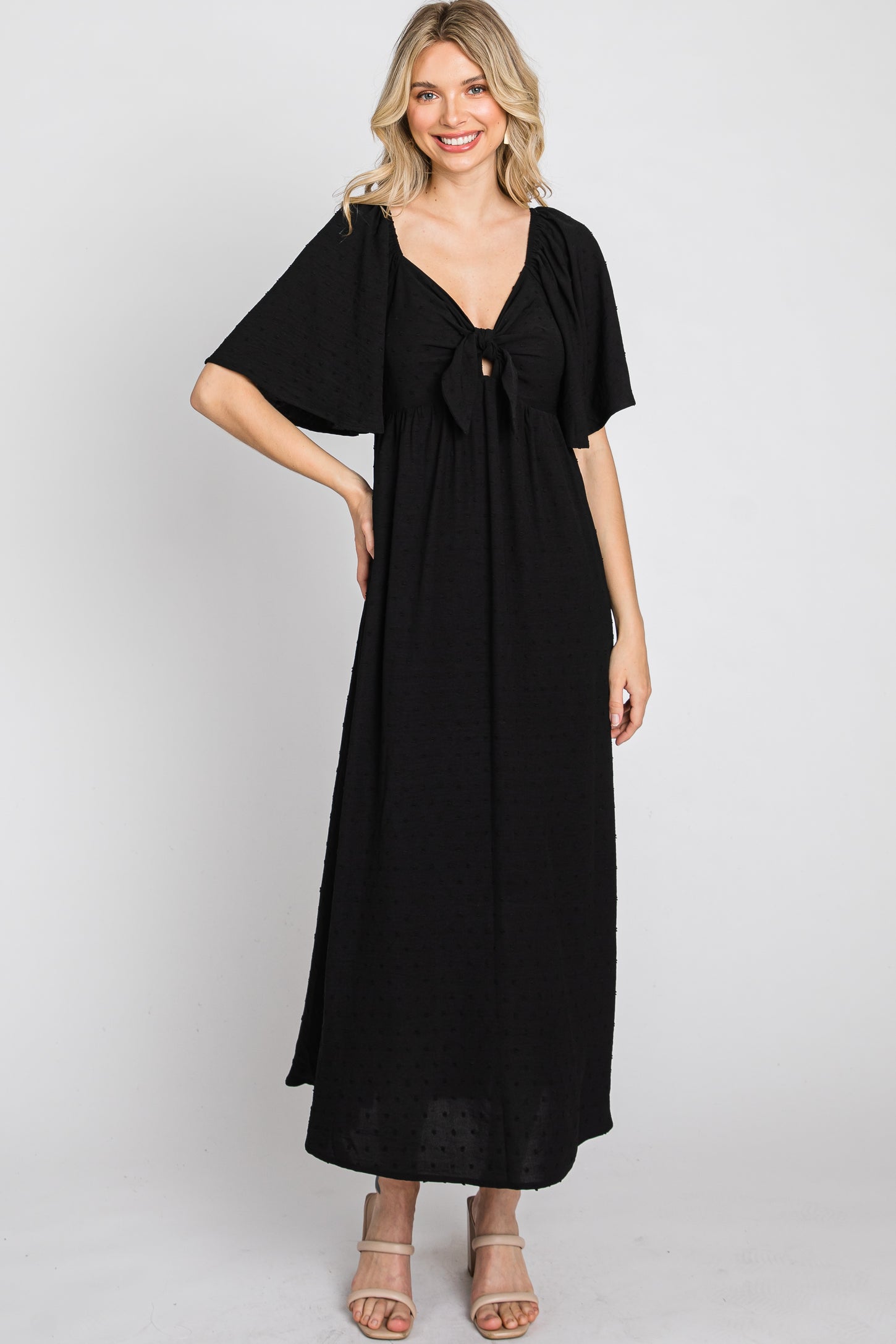 woman wearing a black maxi dress with short sleeves and a front bow detail