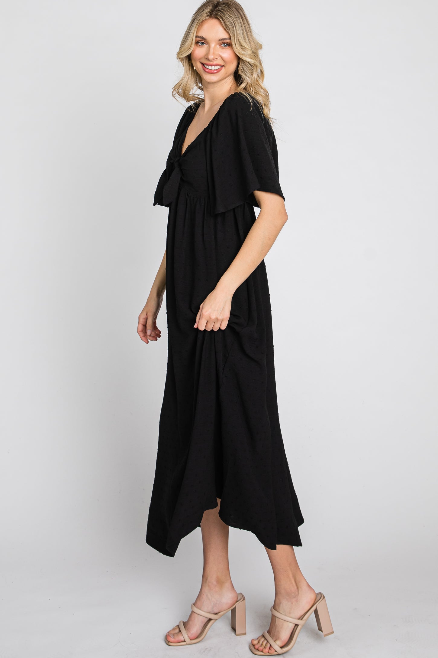 woman wearing a black short sleeve maxi dress with a tie front and a flowy silhouette