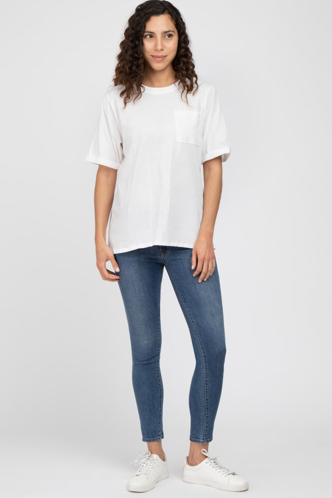 woman wearing a white short sleeve pocket t-shirt and blue skinny jeans with white sneakers