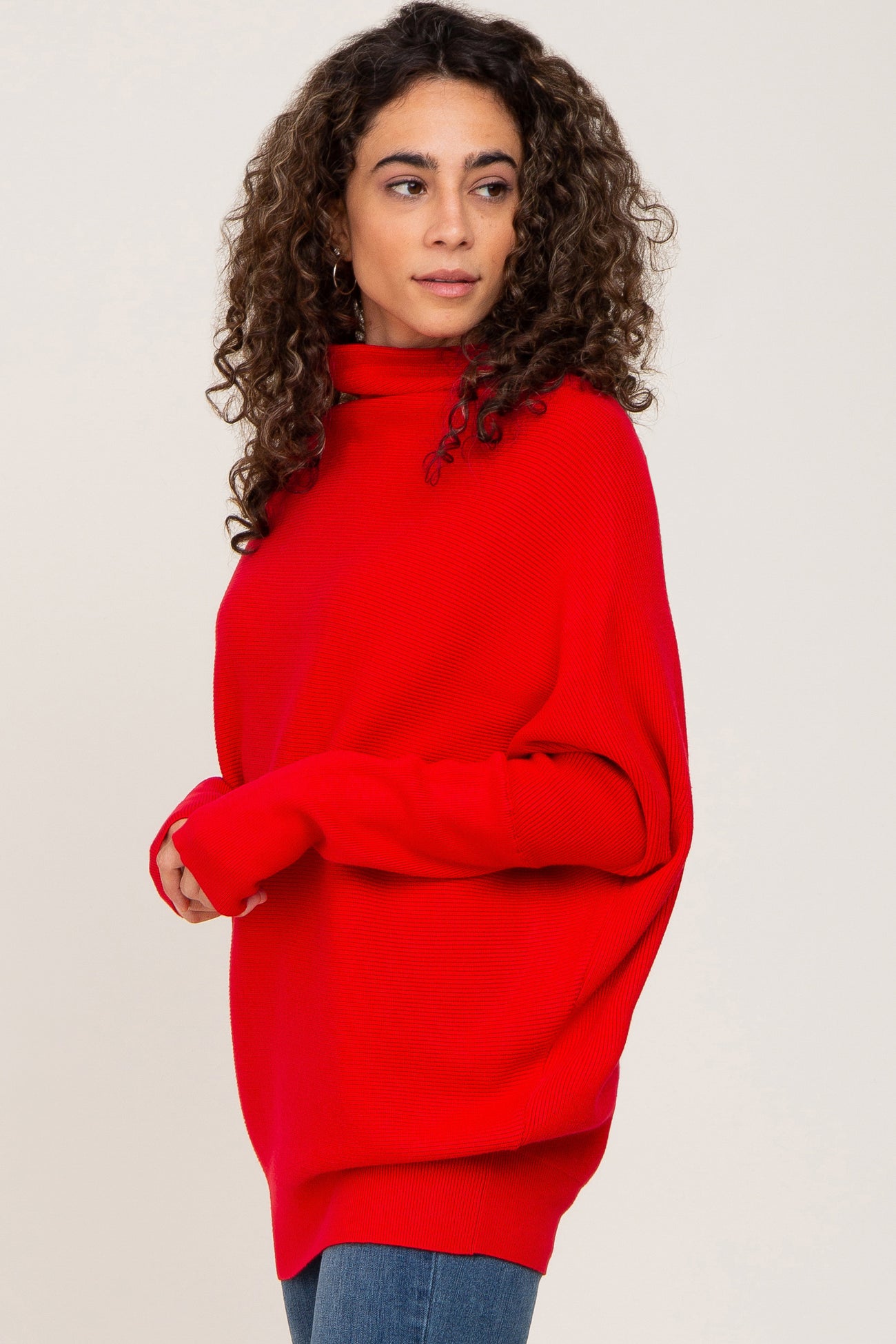 woman wearing a bright red oversized turtleneck sweater with a relaxed fit and long sleeves