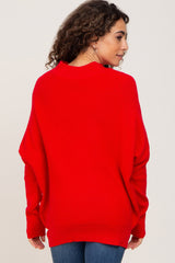 woman wearing a red oversized ribbed sweater viewed from the back with long sleeves and a relaxed fit