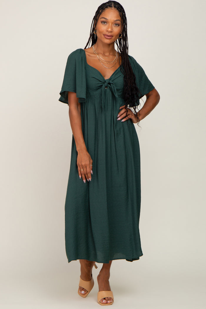 woman wearing a dark green maxi dress with a tied front detail and short flutter sleeves