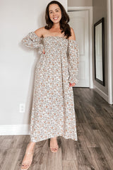 woman wearing a floral off-the-shoulder maxi dress with elastic sleeves and a flowy silhouette