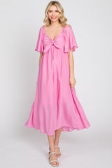 woman wearing a pink midi dress with flutter sleeves and a tied front detail