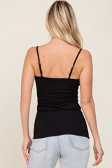 woman wearing a black fitted camisole with adjustable straps, viewed from the back over light blue jeans
