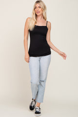woman wearing a black fitted camisole top with adjustable straps paired with light blue ripped jeans and black sneakers
