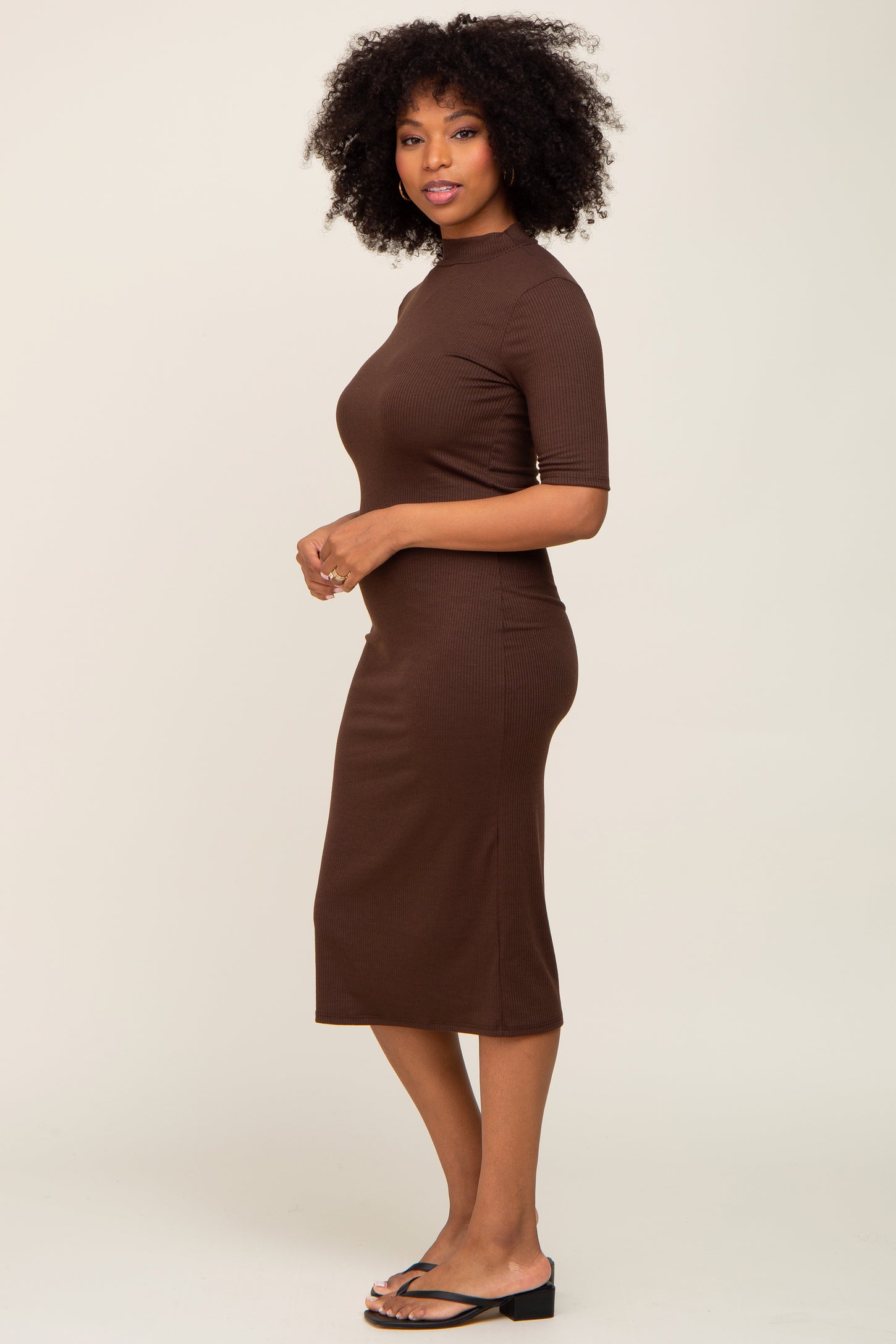 woman wearing a brown ribbed midi dress with short sleeves and a fitted silhouette