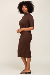 woman wearing a brown ribbed midi dress with short sleeves and a fitted silhouette