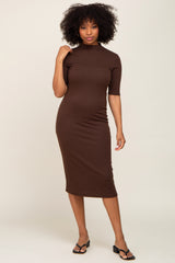woman wearing a brown ribbed midi dress with a high neckline and short sleeves