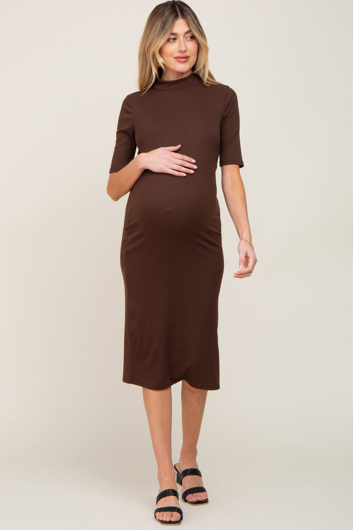 woman wearing a brown ribbed maternity dress with short sleeves and a visible baby bump