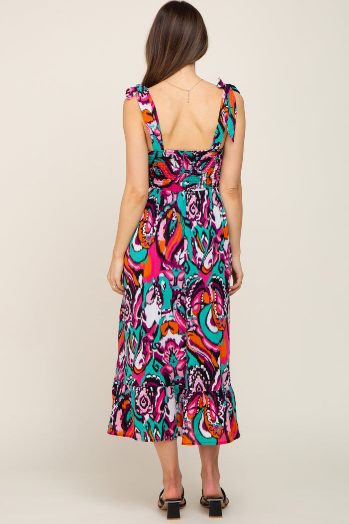 woman wearing a colorful paisley print maternity dress with ruffle straps and a flowy hemline