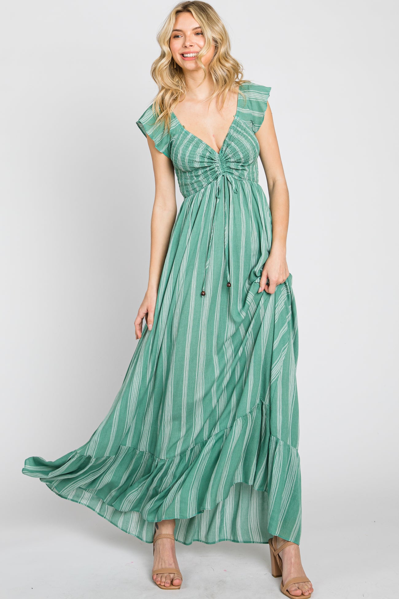 woman wearing a green striped maxi dress with a ruched bodice and ruffled sleeves