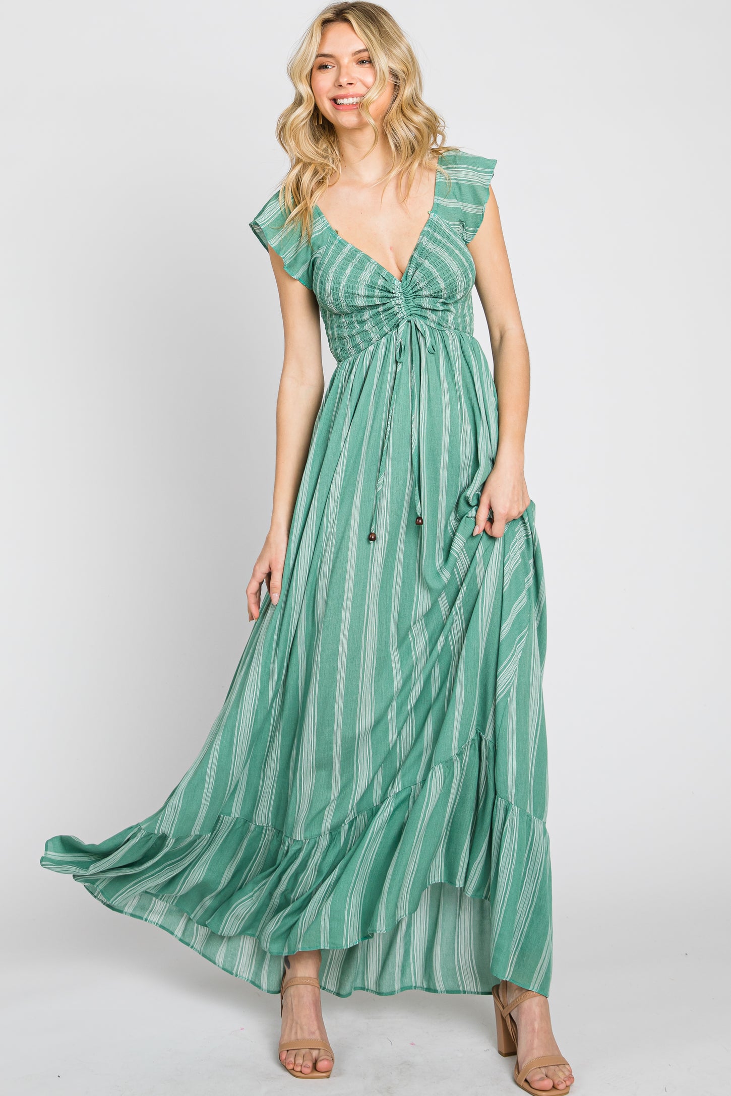 woman wearing a green striped maxi dress with a ruched bodice and ruffled sleeves