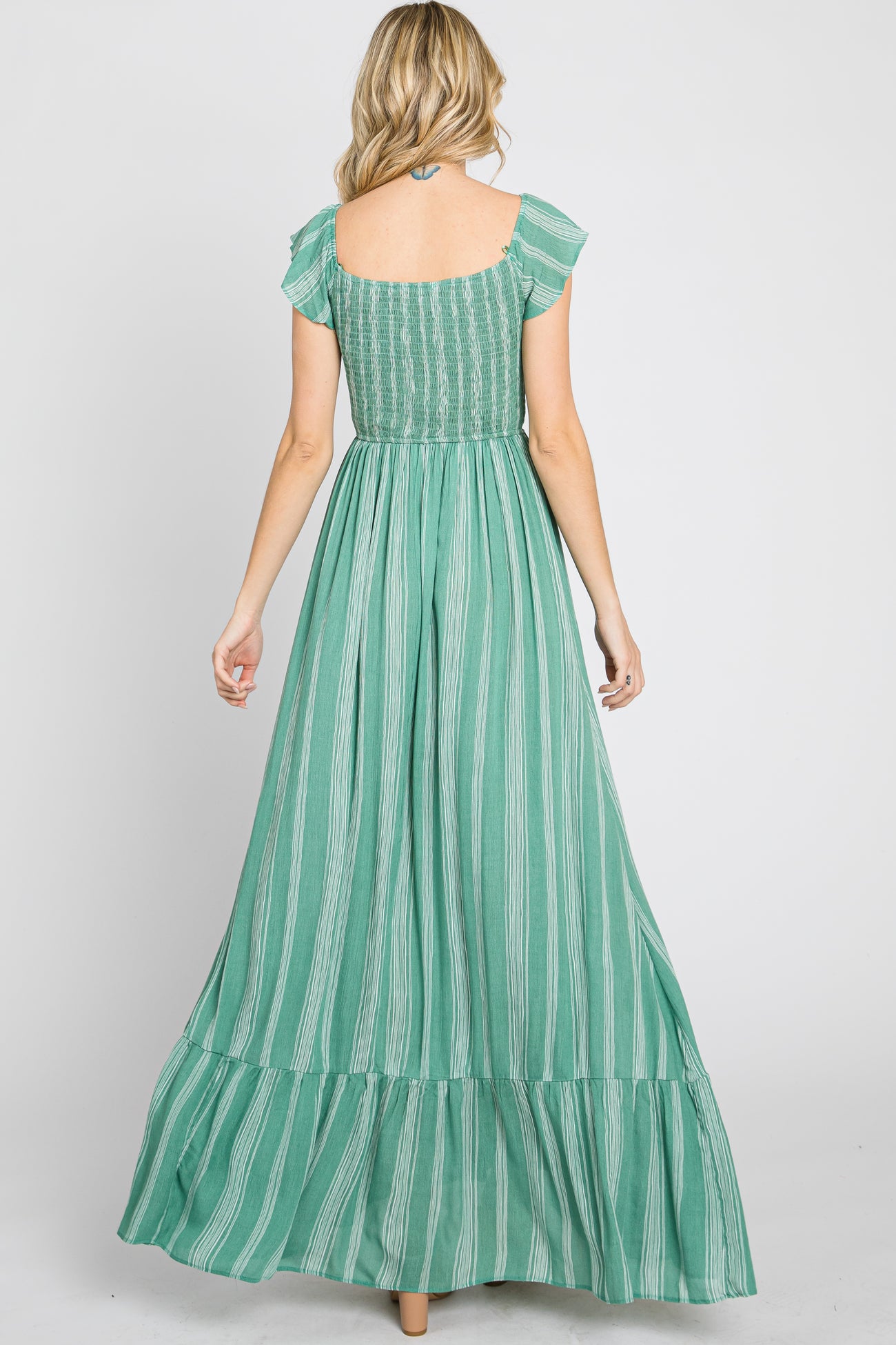 woman wearing a green striped maxi dress with short flutter sleeves and a smocked bodice, shown from the back