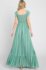 woman wearing a green striped maxi dress with short flutter sleeves and a smocked bodice, shown from the back