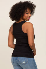 woman wearing a black fitted tank top with ruched sides and blue jeans, showing a rear view with curly hair