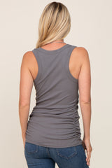 woman wearing a grey sleeveless tank top with gathered side detailing and styled with blue jeans