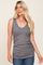 woman wearing a gray ribbed sleeveless v-neck top with gathered sides, paired with blue jeans