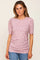 woman wearing a pink floral print short sleeve top with puffed sleeves and a fitted silhouette, paired with blue jeans
