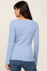 back view of a woman wearing a light blue long-sleeve ribbed top and denim jeans
