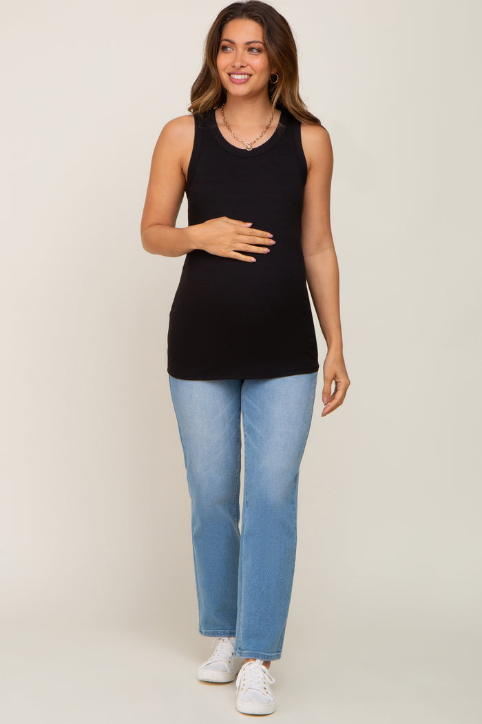 woman wearing a black tank top maternity wear and light blue jeans, holding her baby bump