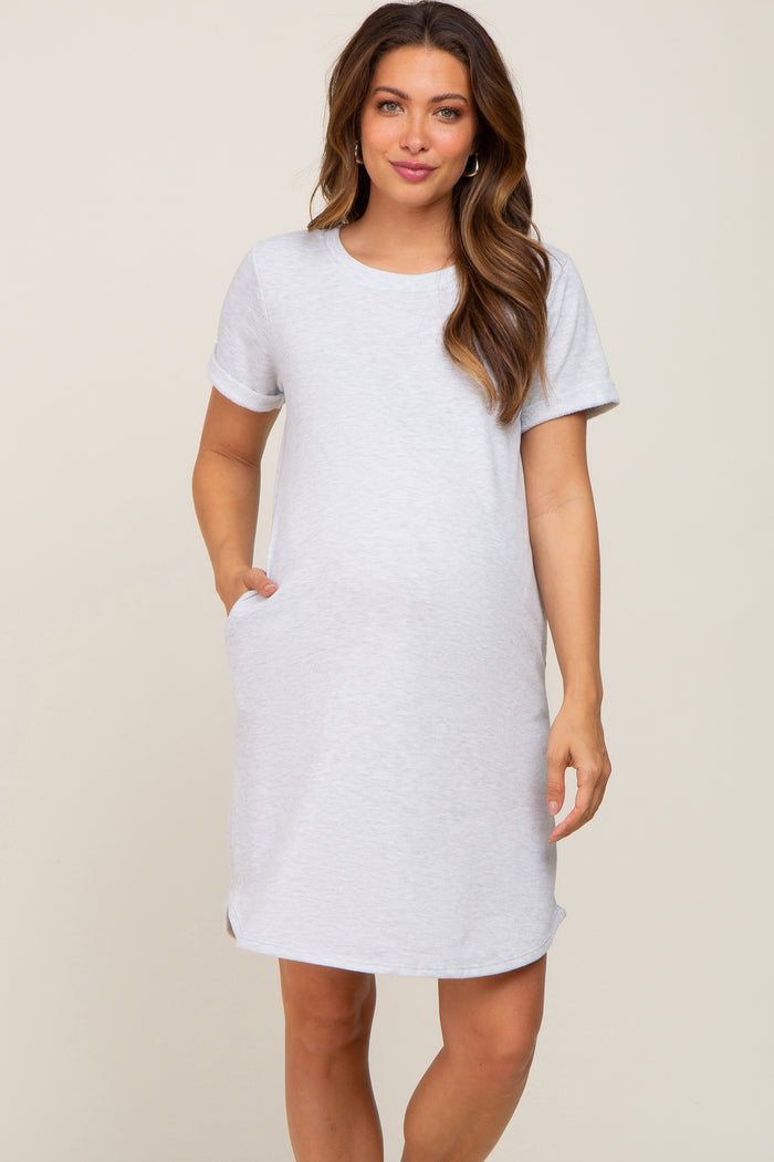 woman wearing a gray short sleeve maternity dress with pockets and a visible baby bump