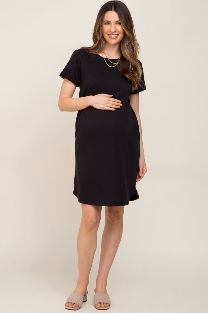 woman wearing a black short sleeve maternity dress and holding her baby bump