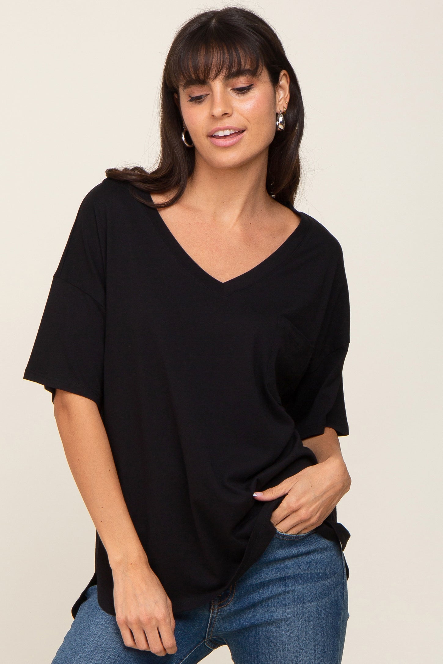 woman wearing a black v-neck short sleeve t-shirt and blue jeans