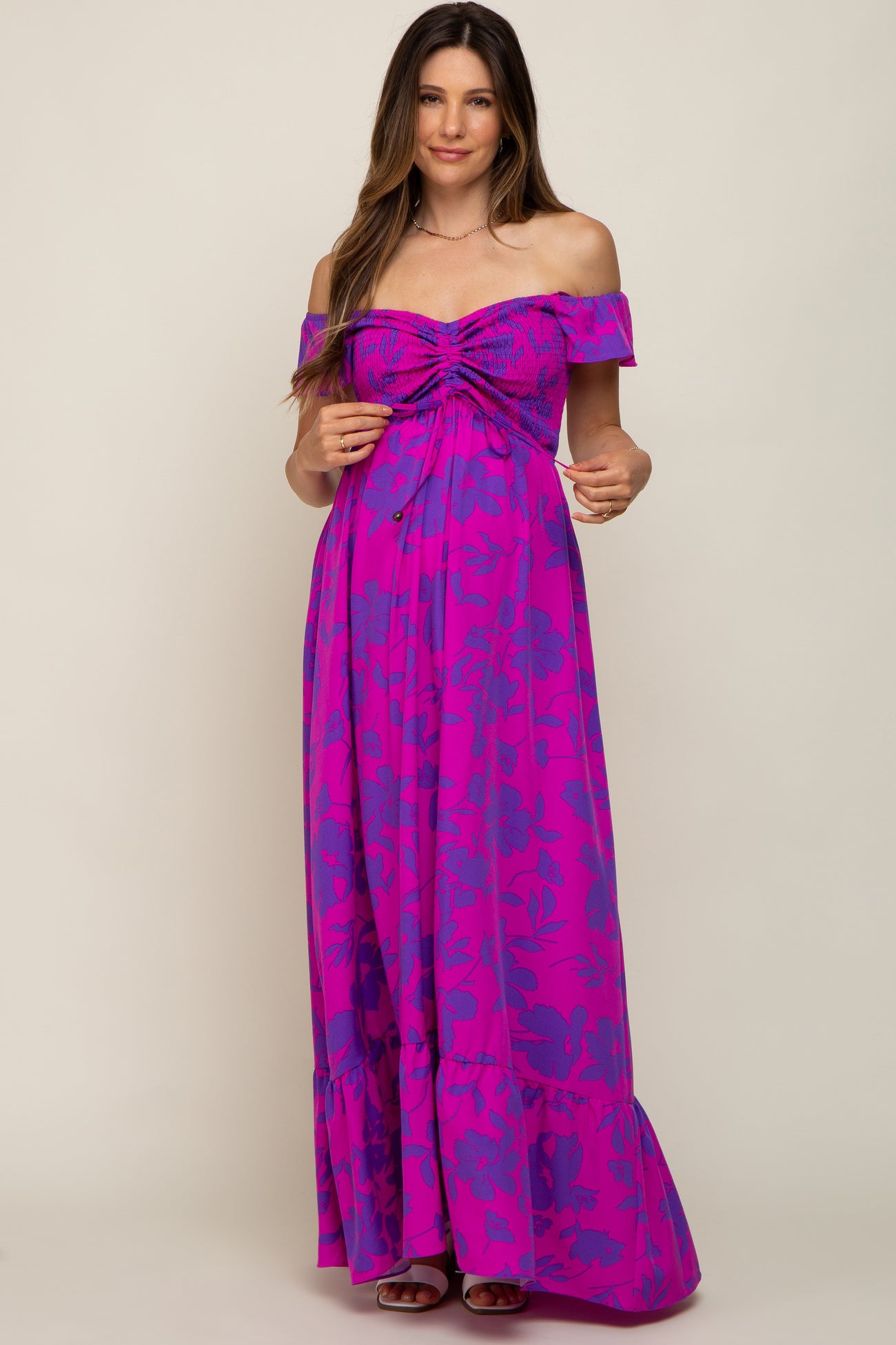 woman wearing a purple and pink floral off-the-shoulder maternity maxi dress