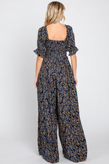 woman wearing a navy blue floral maxi dress with a square back and short ruffled sleeves