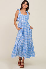 woman wearing a blue and white checkered maxi dress with tie straps and pockets