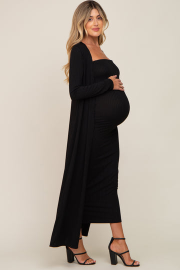 pregnant woman in black ribbed maternity midi dress and matching long cardigan with black heels