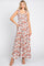 woman wearing a floral maxi dress with square neckline and tie straps, styled with nude high-heeled sandals
