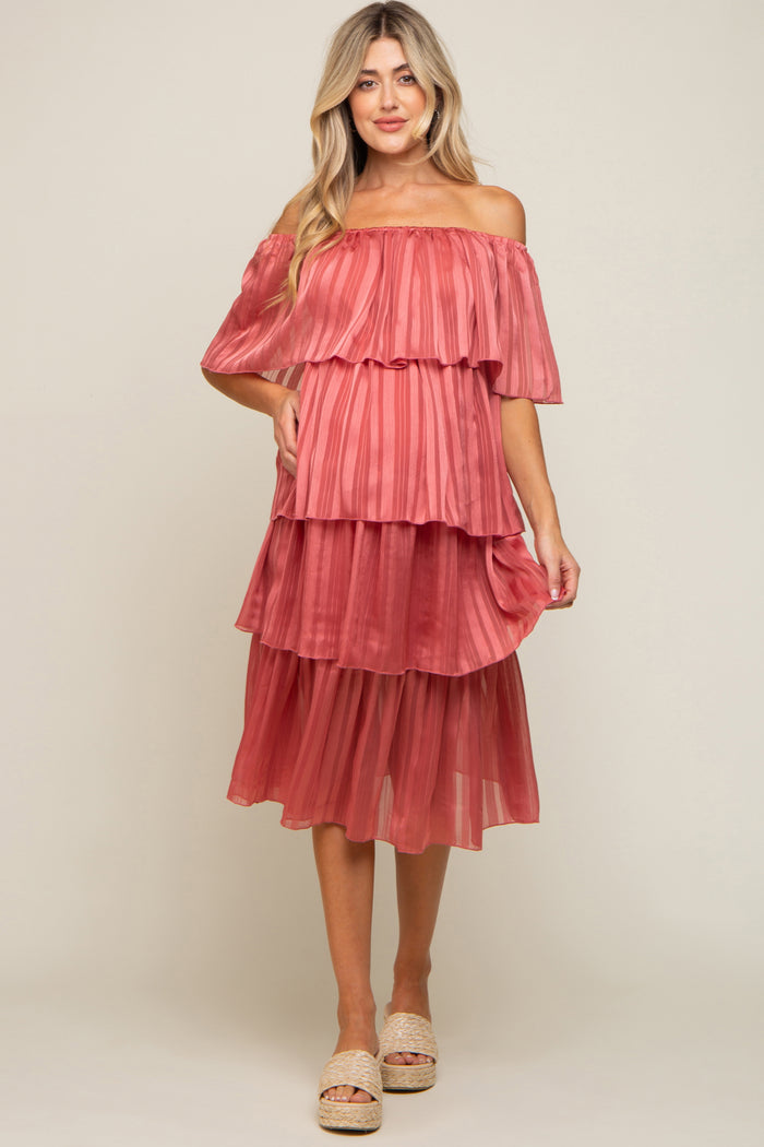 woman wearing a pink off-the-shoulder tiered maternity dress with a flowy silhouette and layered fabric