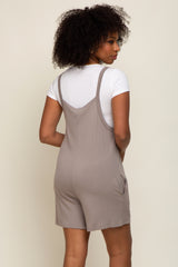 woman wearing a gray sleeveless romper with side pockets and a white fitted t-shirt underneath