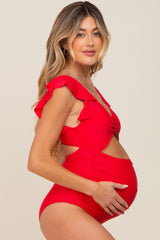 woman wearing a red maternity one-piece swimsuit with ruffle details and showcasing her baby bump