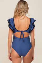 woman wearing a navy blue maternity swimsuit with ruffled sleeves and a tie back detail