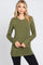 woman wearing an olive green long sleeve top paired with black leggings