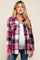 woman wearing a pink and black plaid maternity shirt with buttons and two chest pockets, displaying her baby bump