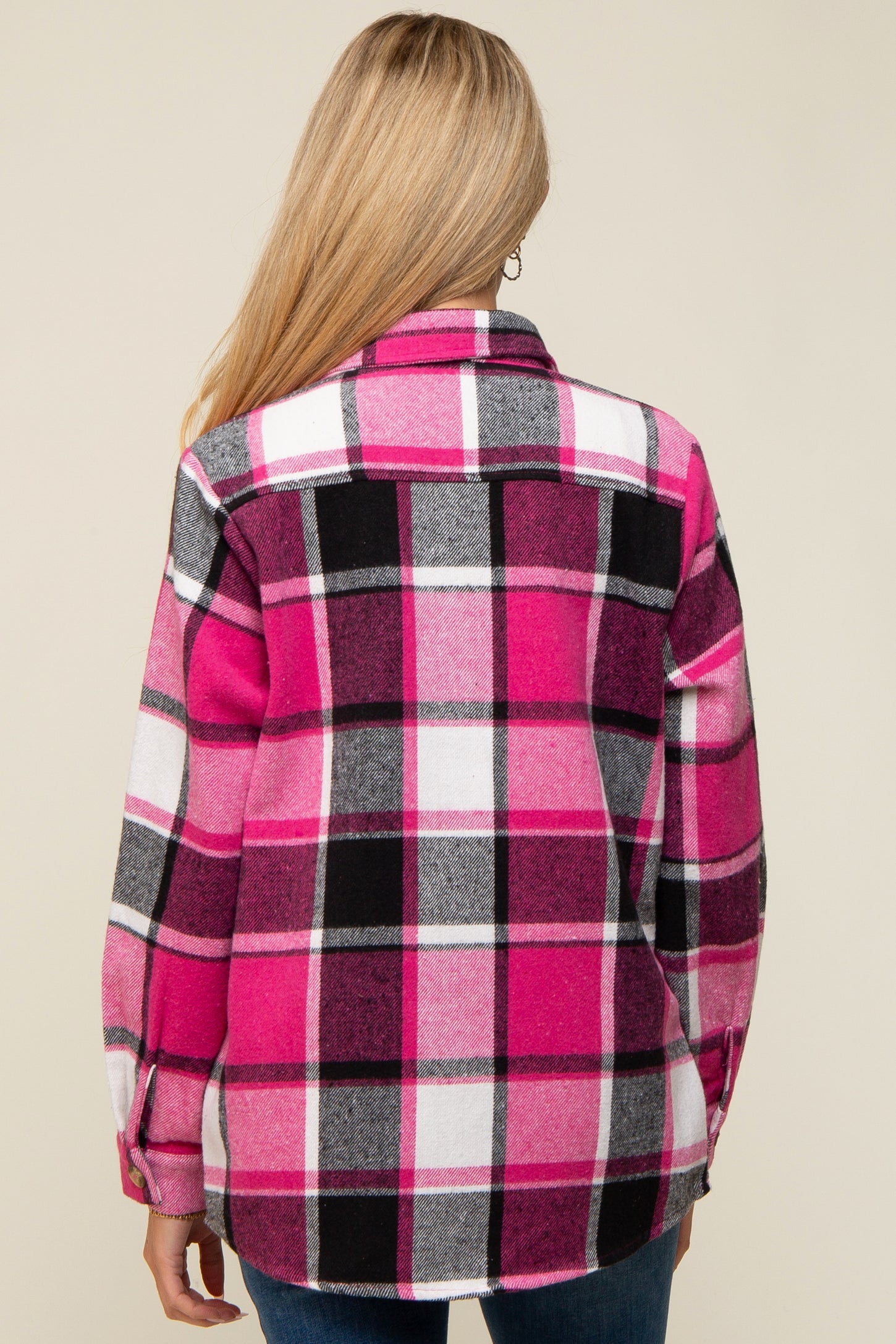 woman wearing a pink and black plaid maternity flannel shirt, showing the back view