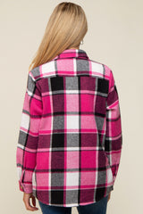 woman wearing a pink and black plaid maternity flannel shirt, showing the back view