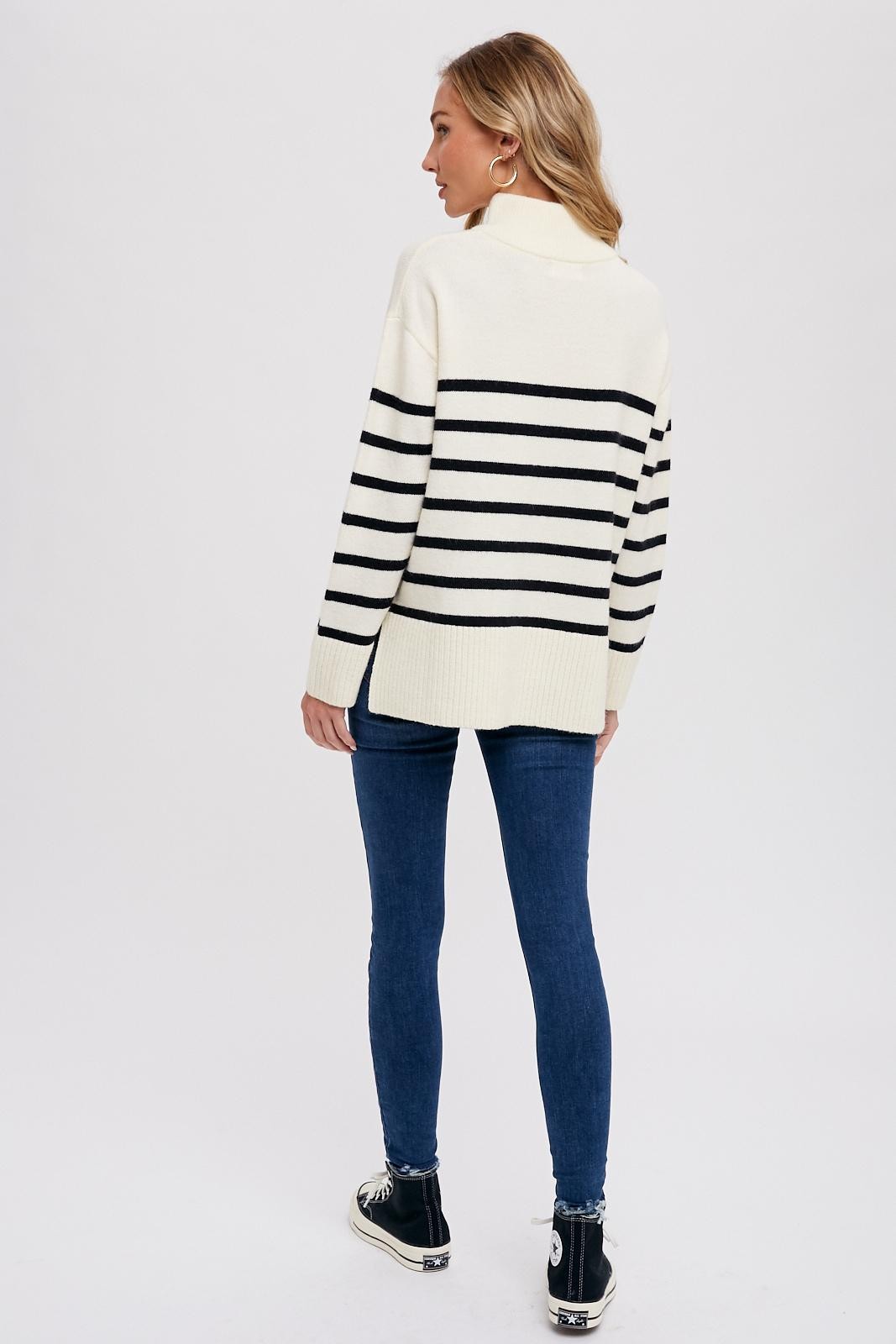 woman wearing a cream and black striped oversized sweater paired with skinny jeans and high-top sneakers, seen from the back