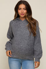 woman wearing a gray maternity hoodie with a relaxed fit and balloon sleeves, posing with a slight smile