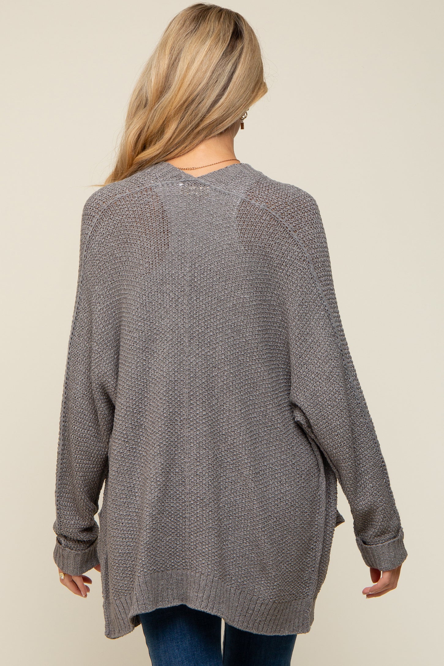 woman wearing a relaxed fit gray maternity sweater with long sleeves and a loose silhouette