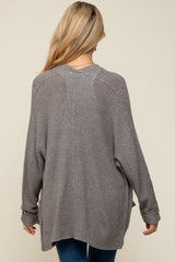 woman wearing a relaxed fit gray maternity sweater with long sleeves and a loose silhouette