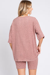 woman wearing a pink ribbed oversized top and matching shorts, viewed from the back