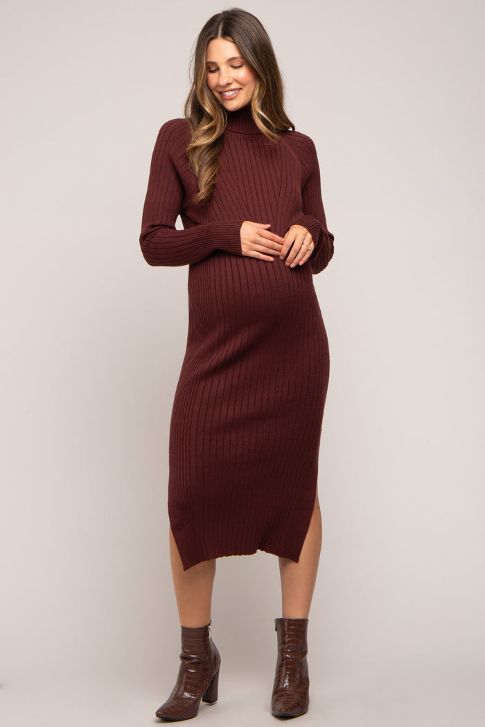 woman wearing a burgundy ribbed maternity dress with long sleeves and a side slit, showing her baby bump