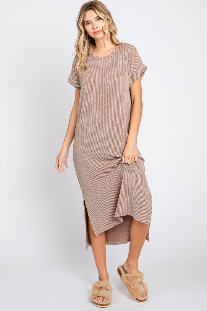 woman wearing a brown striped short sleeve maxi dress with side slits and tan fuzzy slippers