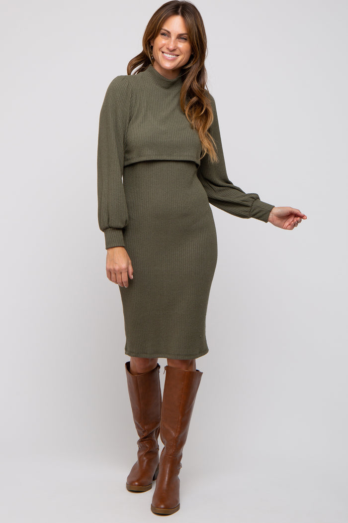 woman wearing an olive green ribbed sweater dress with long sleeves and a mock neck, paired with brown knee-high boots